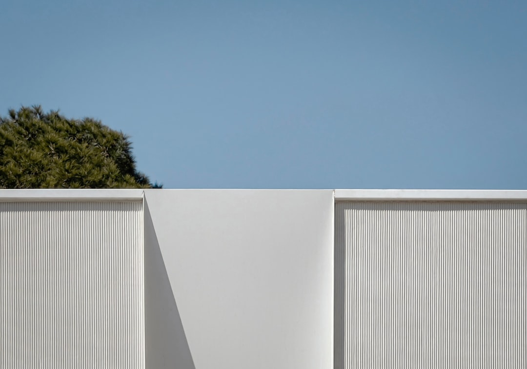 樹木を背景にした白い壁の構成