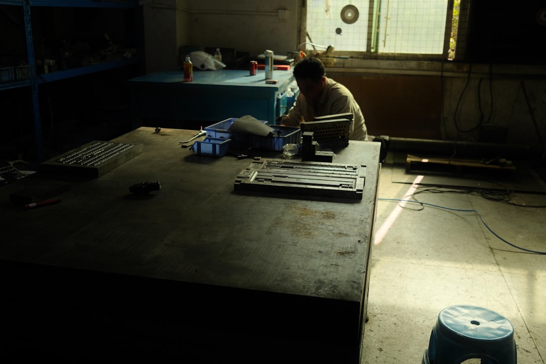 Man working at a large table in a workshop.