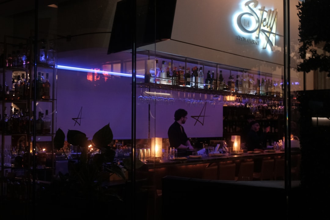 Dj performing at a nightclub with purple lighting